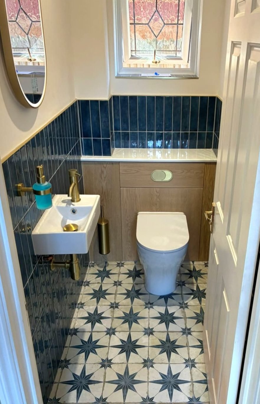 Small downstairs cloakroom with wall hung basin, gold taps and back to wall WC